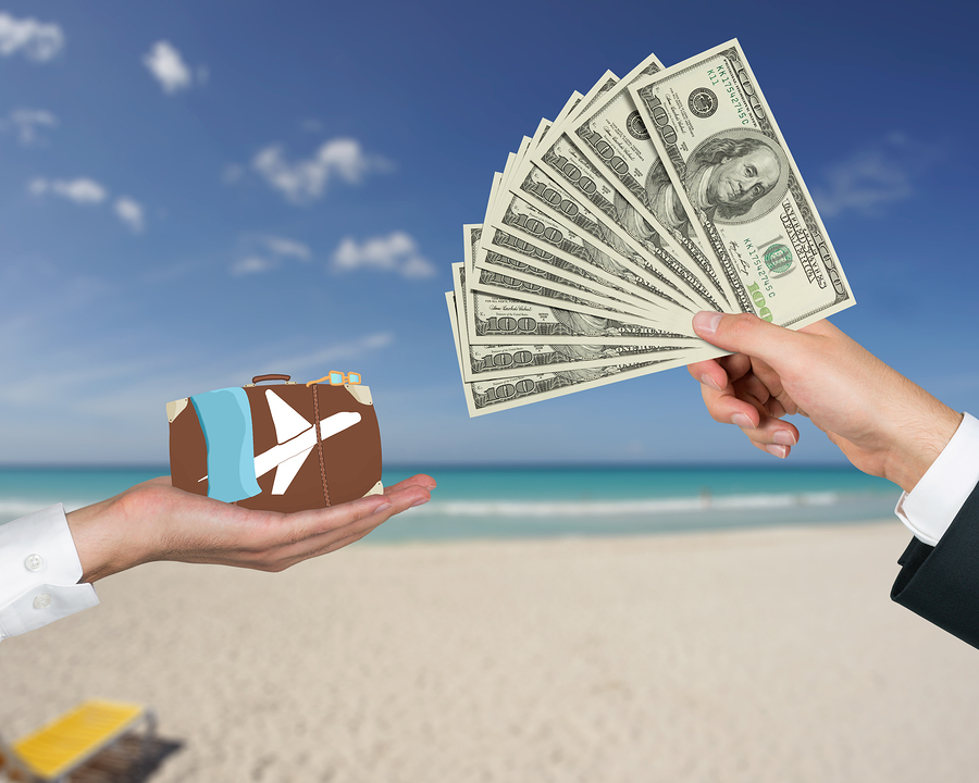 hand giving money for travel on a beach background